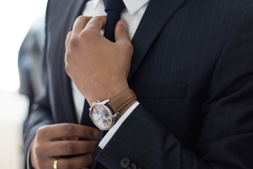 man adjusting tie